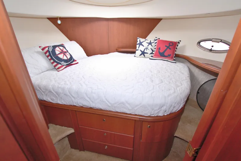 Slide: The Image of Cozy bedroom in 2006 Silverton 39 Motor Yacht with nautical-themed pillows and wooden cabinetry. - 47