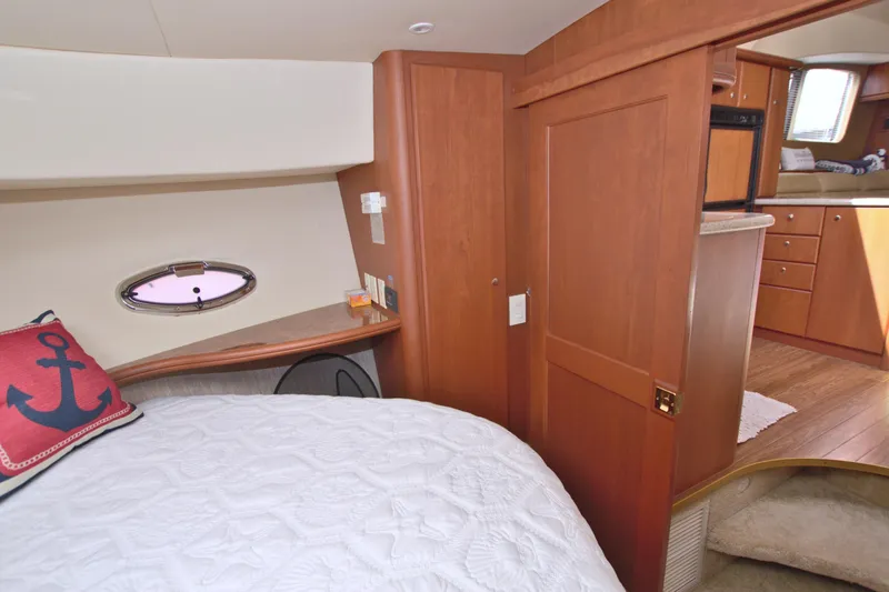 Slide: The Image of 2006 Silverton 39 Motor Yacht interior with cozy bedroom and wooden cabinetry. - 49