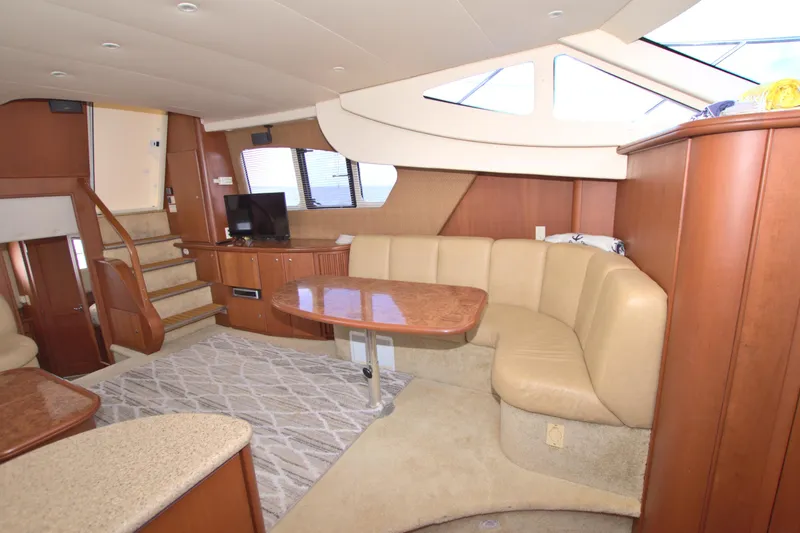 Slide: The Image of 2006 Silverton 39 Motor Yacht interior with beige seating, wooden accents, and a TV. - 55