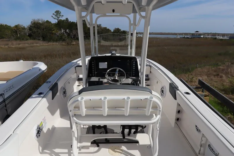 Slide: The Image of 2021 Robalo R242 Explorer boat interior with helm and seating, docked near marshland. - 13