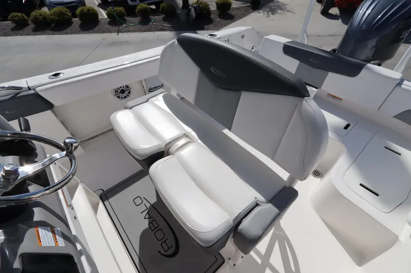 Slide: The Image of 2021 Robalo R242 Explorer boat interior with cushioned seating and steering wheel. - 16