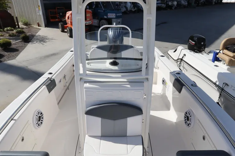 Slide: The Image of 2021 Robalo R242 Explorer boat interior with seating and console, docked outdoors. - 17