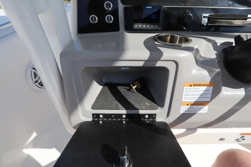 Slide: The Image of 2021 Robalo R242 Explorer boat dashboard with storage compartment and controls. - 22