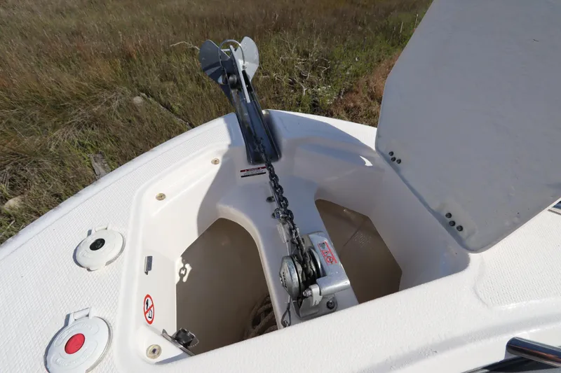 Slide: The Image of 2021 Robalo R242 Explorer anchor compartment with open hatch, showcasing anchor and chain mechanism. - 36
