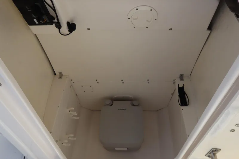 Slide: The Image of Interior of 2021 Robalo R242 Explorer boat, featuring a compact marine toilet. - 45