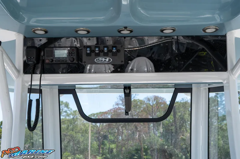 Slide: The Image of 2021 Sea Hunt ULTRA 305 boat dashboard with controls and radio equipment. - 13