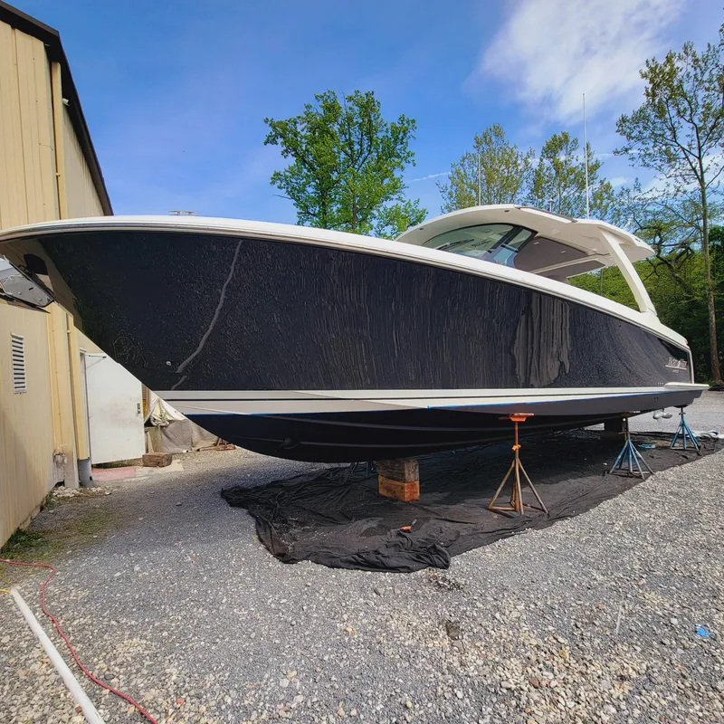 Slide: The Image of 2021 Tiara Yachts 38 LS boat on dry dock, black hull, outdoor setting. - 27