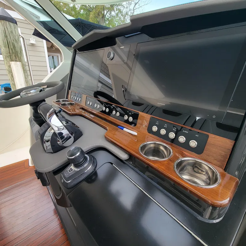 Slide: The Image of 2021 Tiara Yachts 38 LS helm with modern controls and wooden accents. - 3