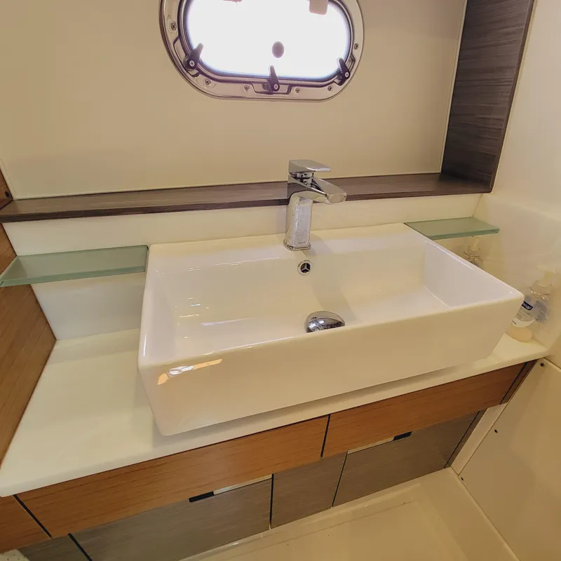 Slide: The Image of Modern bathroom sink in 2021 Tiara Yachts 38 LS, featuring sleek design and porthole window. - 35