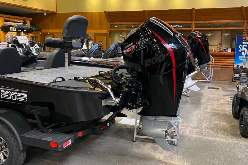 Slide: The Image of 2025 Tracker Savage 215 boat with powerful outboard motor in showroom display. - 3