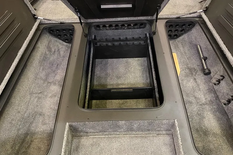 Slide: The Image of Interior storage compartment of 2025 Tracker Savage 215 boat, featuring carpeted flooring and organized layout. - 6