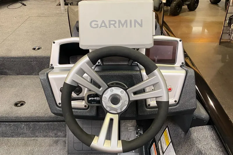 Slide: The Image of Steering wheel and Garmin display on 2025 Tracker Savage 215 boat dashboard. - 7