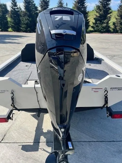Slide: The Image of 2025 Tracker Pro Team 175 boat with Mercury 75 outboard motor, parked outdoors. - 2