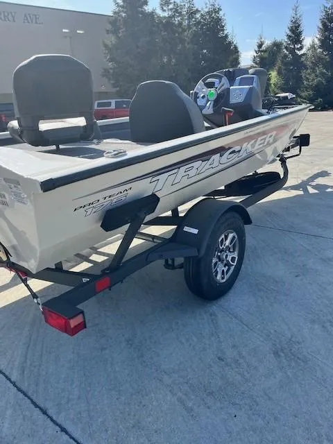 Slide: The Image of 2025 Tracker Pro Team 175 boat on trailer, parked outdoors, with visible seats and steering console. - 5