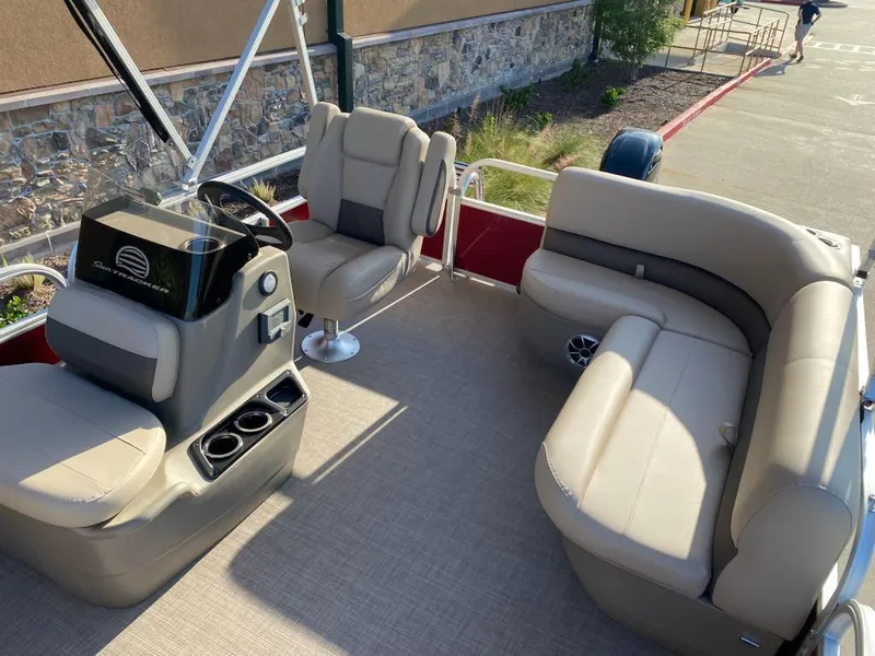 Slide: The Image of 2025 Sun Tracker Bass Buggy 16 XL Select pontoon boat interior with beige seating and steering console. - 6