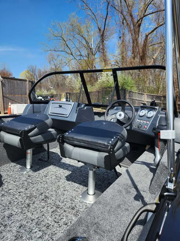 Slide: The Image of 2025 Tracker Pro Guide V-16 WT boat interior with modern dashboard and seating. - 2