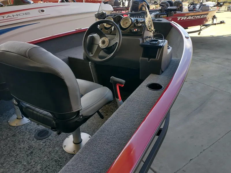 Slide: The Image of 2025 Tracker Super Guide V-16 SC boat interior with steering wheel and seating. - 2