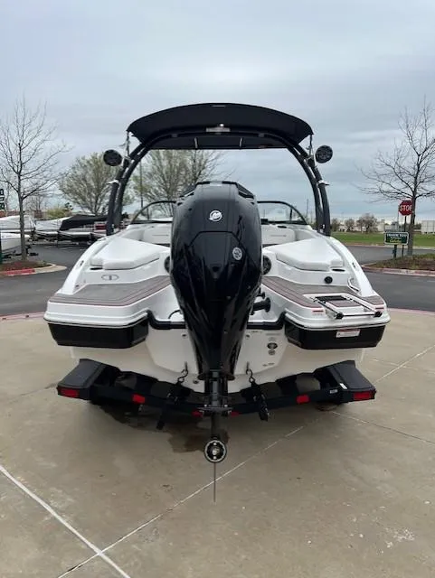 Slide: The Image of 2024 Tahoe 210 S boat, rear view with outboard motor, parked on concrete. - 4