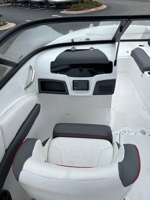 Slide: The Image of 2024 Tahoe 210 S boat interior with white and gray seating, dashboard, and steering wheel. - 7