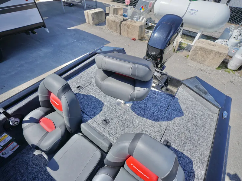 Slide: The Image of 2025 Tracker Pro Team 175 boat interior with gray and red seating, outboard motor visible. - 11