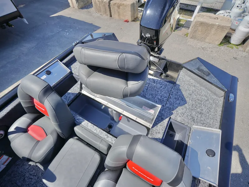 Slide: The Image of 2025 Tracker Pro Team 175 boat interior with gray and red seating, and motor view. - 12