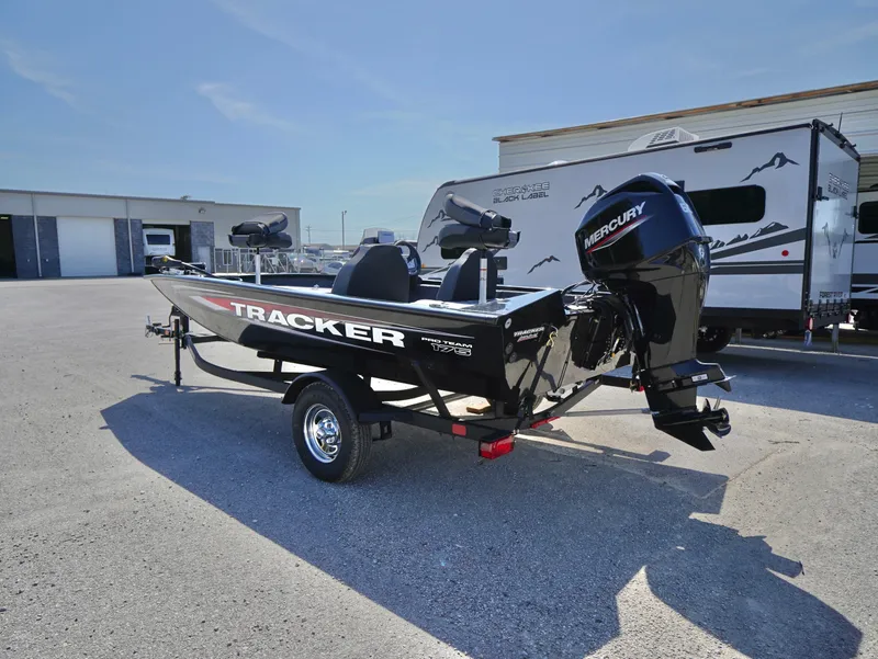 Slide: The Image of 2025 Tracker Pro Team 175 boat with Mercury engine, parked outdoors near RV. - 3