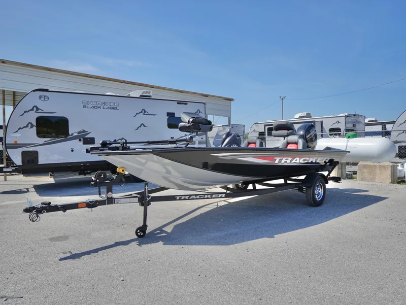 Slide: The Image of 2025 Tracker Pro Team 175 boat on trailer, parked near RVs under clear blue sky. - 5