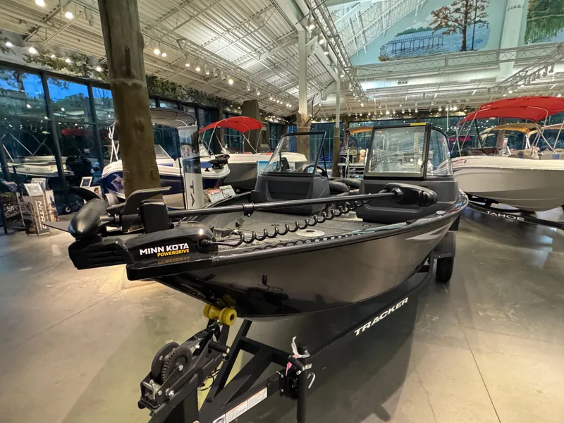 Slide: The Image of 2025 Tracker Pro Guide V-16 WT boat displayed in a showroom with modern lighting. - 2