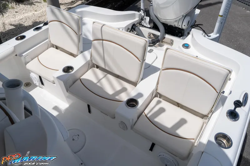 Slide: The Image of 2022 Sea Hunt BX 25 FS boat interior with three white cushioned seats and cup holders. - 16