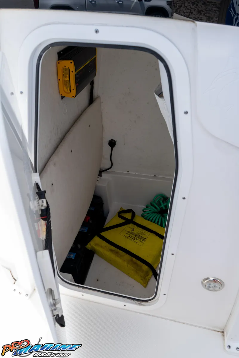 Slide: The Image of 2022 Sea Hunt BX 25 FS boat storage compartment with safety equipment and coiled rope. - 19