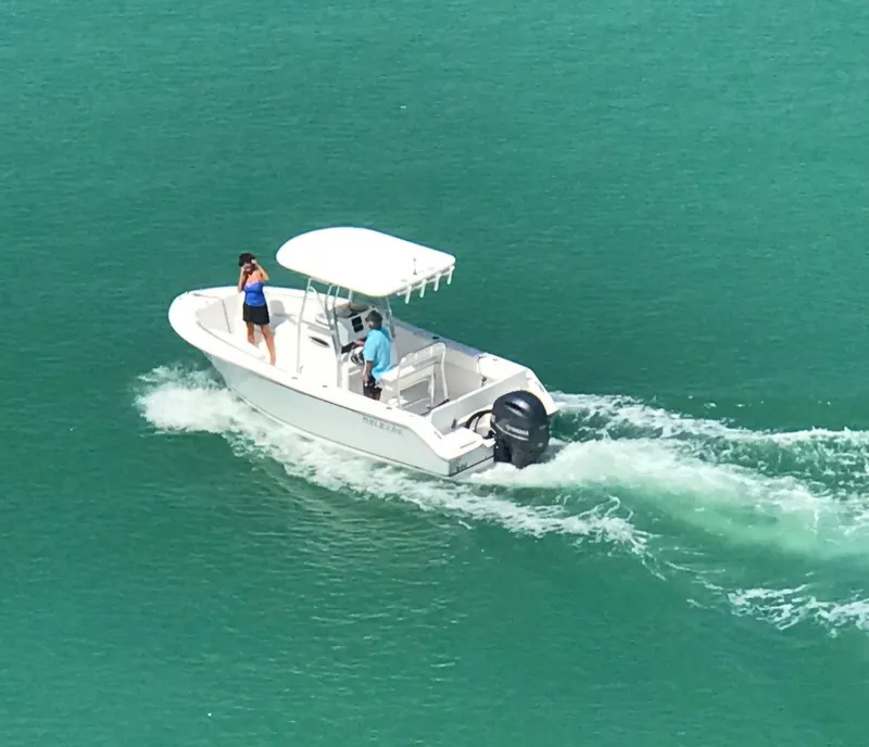 Slide: The Image of 2018 Release 208 SXC boat cruising on turquoise water with two passengers. - 4