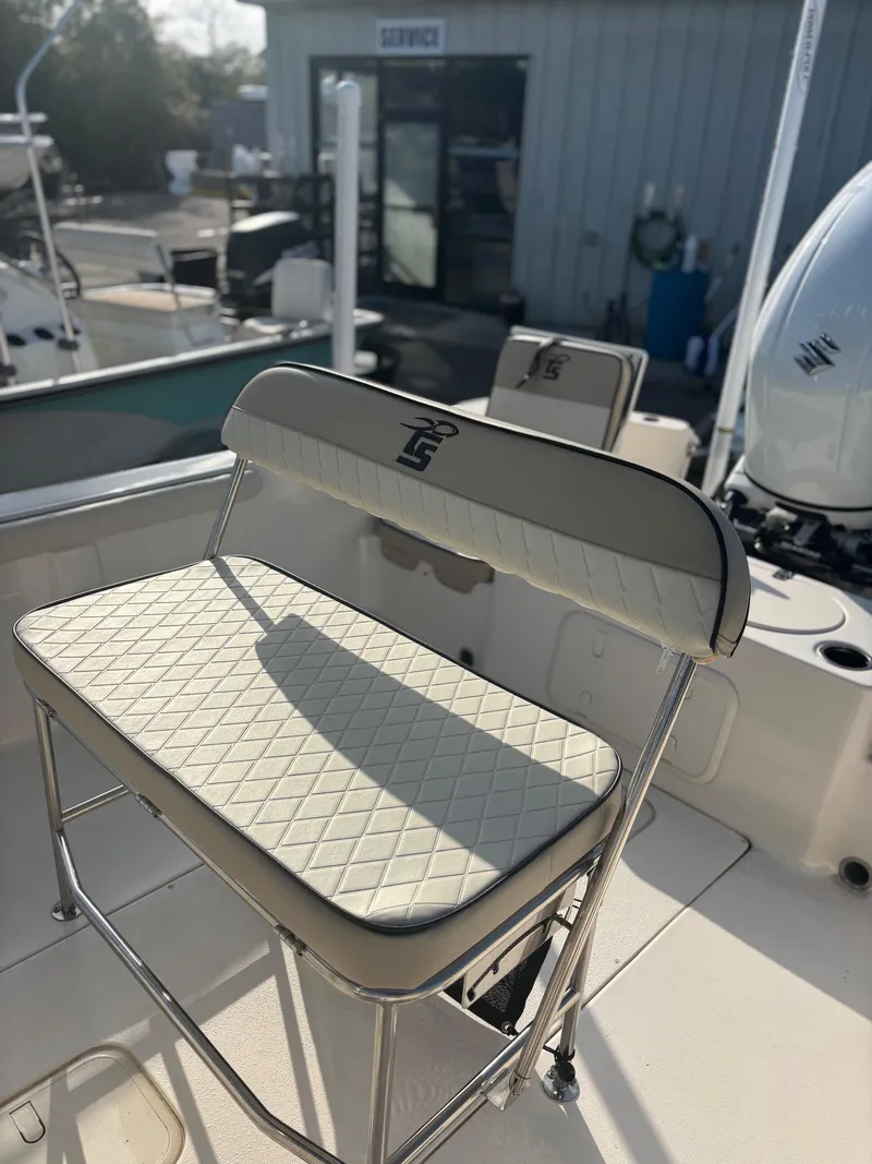 Slide: The Image of 2023 Carolina Skiff 21 LS boat seat with quilted design in a sunny marina setting. - 6