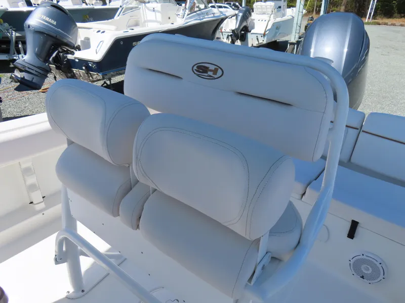 Slide: The Image of 2021 Sea Hunt Ultra 219 boat seating with white cushioned seats and Yamaha outboard motor. - 22