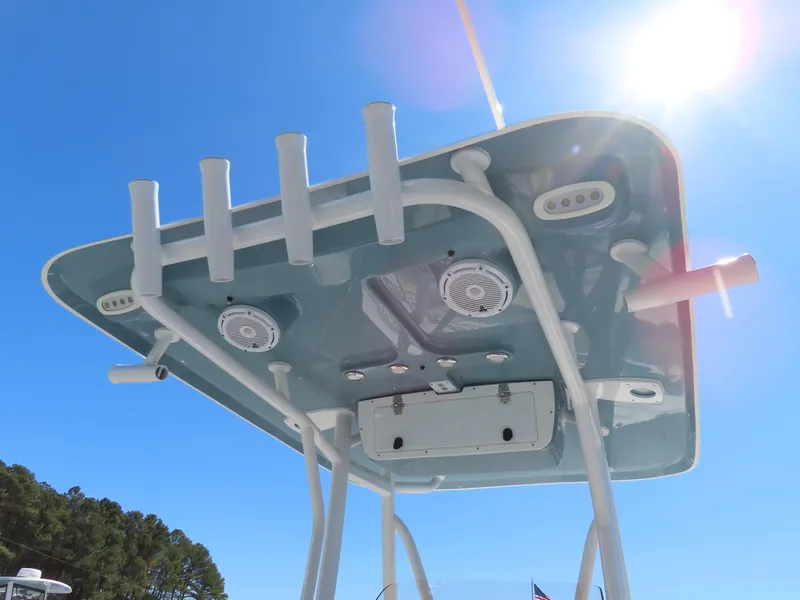 Slide: The Image of 2021 Sea Hunt Ultra 219 boat canopy with rod holders and speakers under sunny sky. - 29