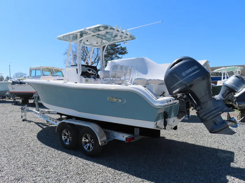 Slide: The Image of 2021 Sea Hunt Ultra 219 boat on trailer with Yamaha outboard motor, parked outdoors. - 3