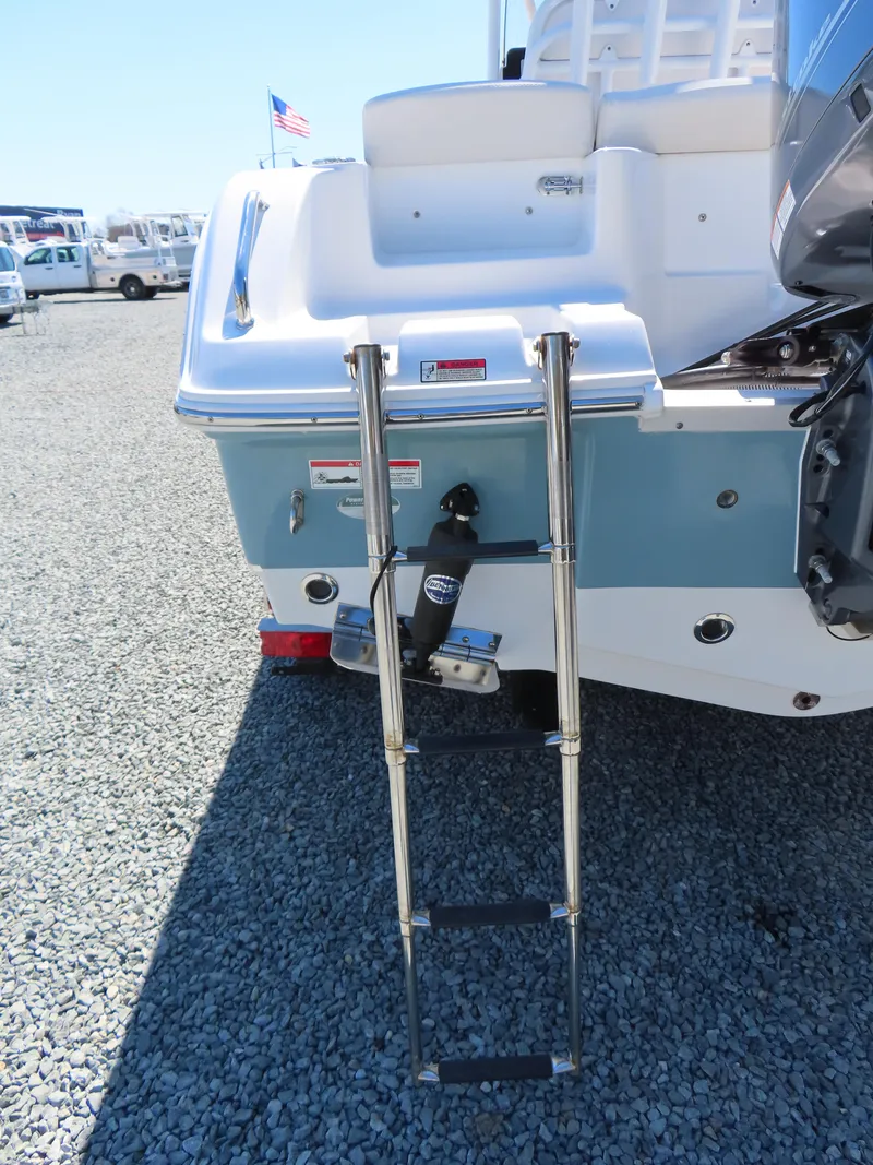 Slide: The Image of 2021 Sea Hunt Ultra 219 boat with a retractable swim ladder on a gravel surface. - 6