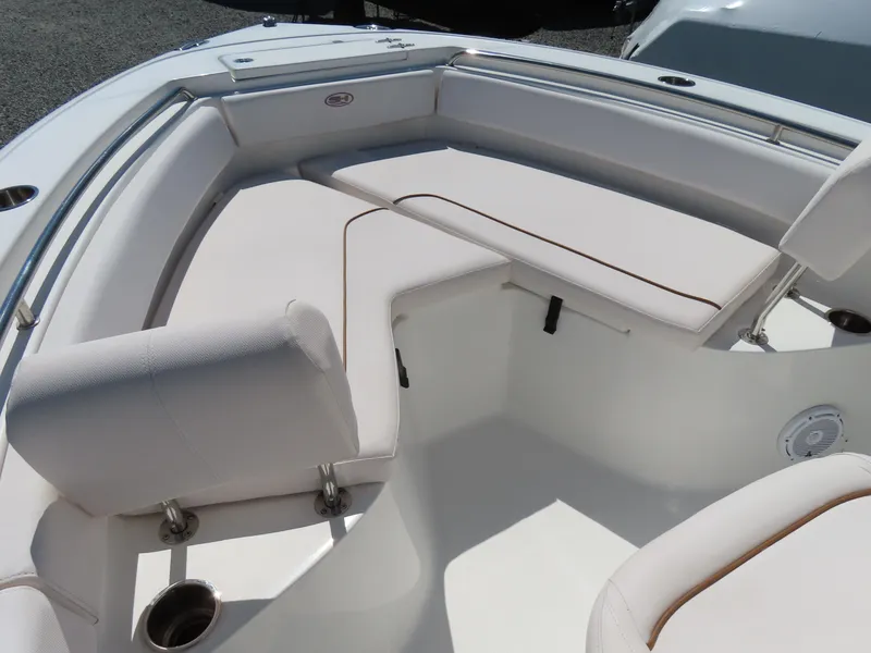 Slide: The Image of 2021 Sea Hunt Ultra 219 boat interior with white cushioned seating and cup holders. - 7