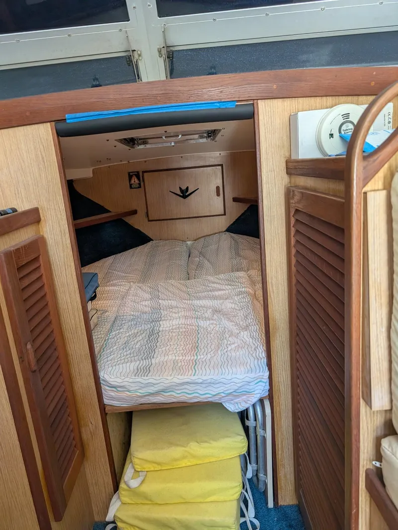 Slide: The Image of 1979 Bertram 28 Flybridge Cruiser cabin with cozy bed and wooden interior. - 10