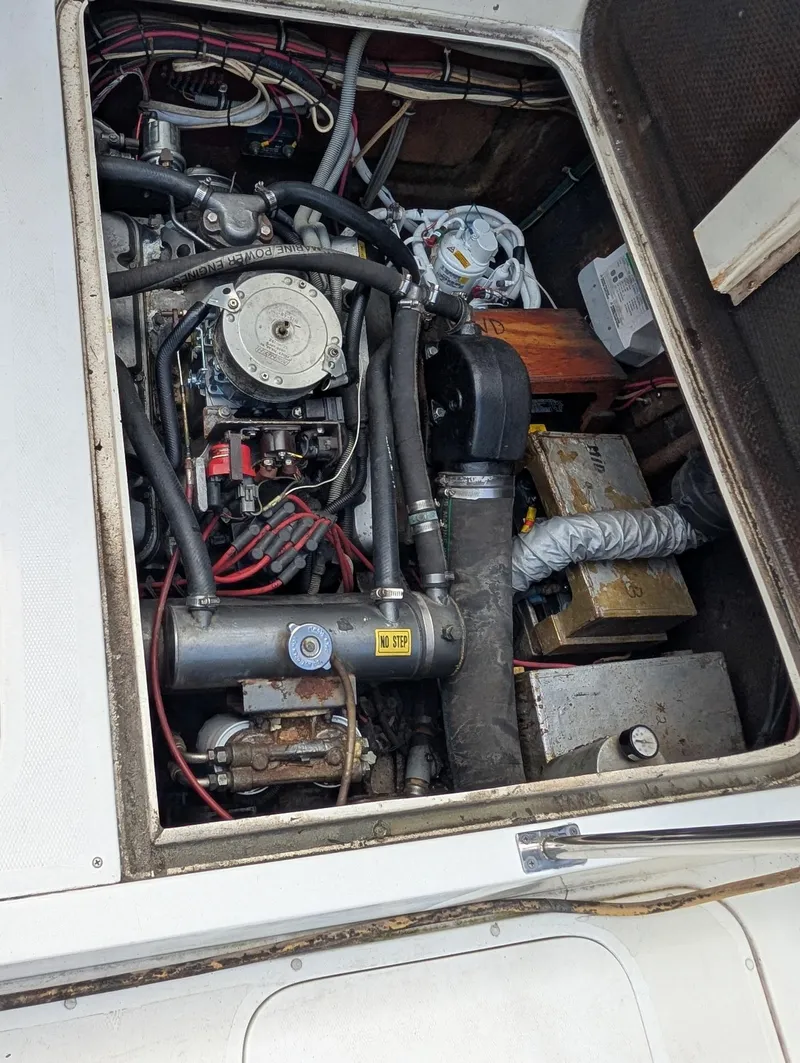 Slide: The Image of Engine compartment of a 1979 Bertram 28 Flybridge Cruiser, showcasing mechanical components and wiring. - 12