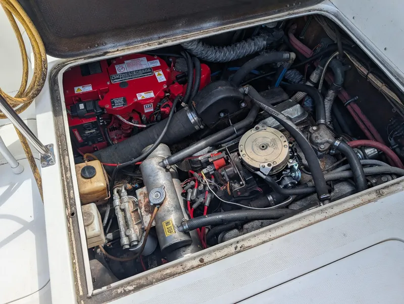 Slide: The Image of Engine compartment of a 1979 Bertram 28 Flybridge Cruiser, showcasing mechanical components and wiring. - 13