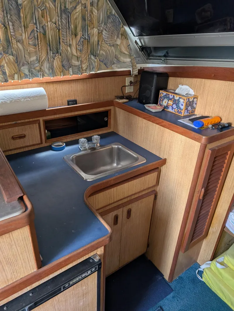 Slide: The Image of 1979 Bertram 28 Flybridge Cruiser interior with compact kitchen and sink. - 6