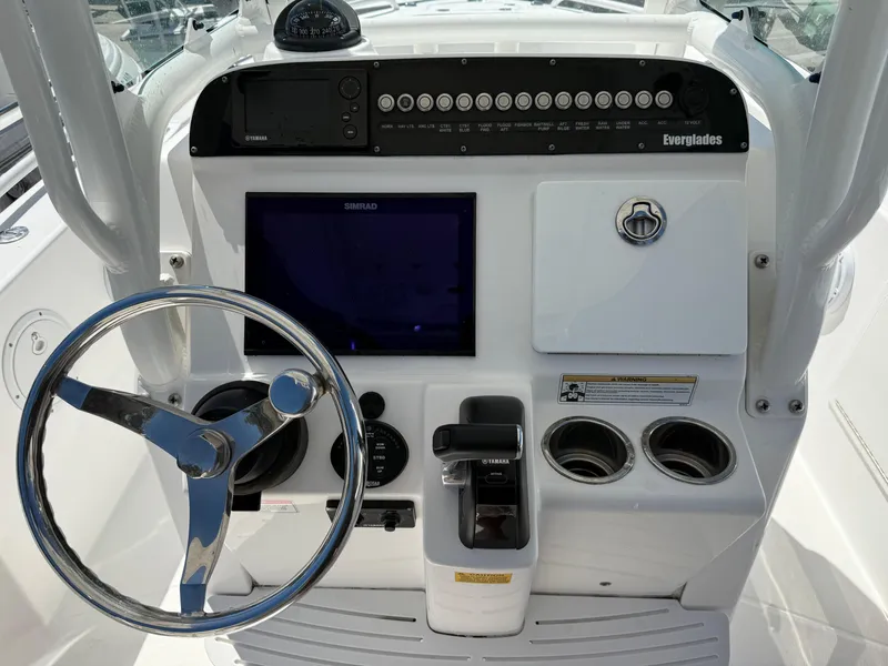 Slide: The Image of 2018 Everglades 230 Center Console boat dashboard with steering wheel and control panel. - 33