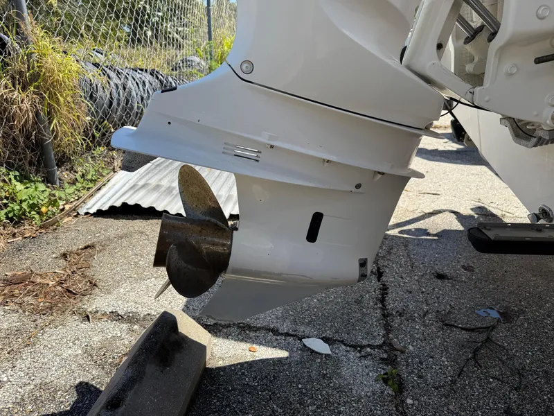 Slide: The Image of Outboard motor of 2018 Everglades 230 Center Console on pavement, near chain-link fence. - 7