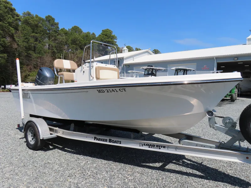 Slide: The Image of 2018 Parker 1801 Center Console boat on trailer, parked outdoors near trees and a building. - 0