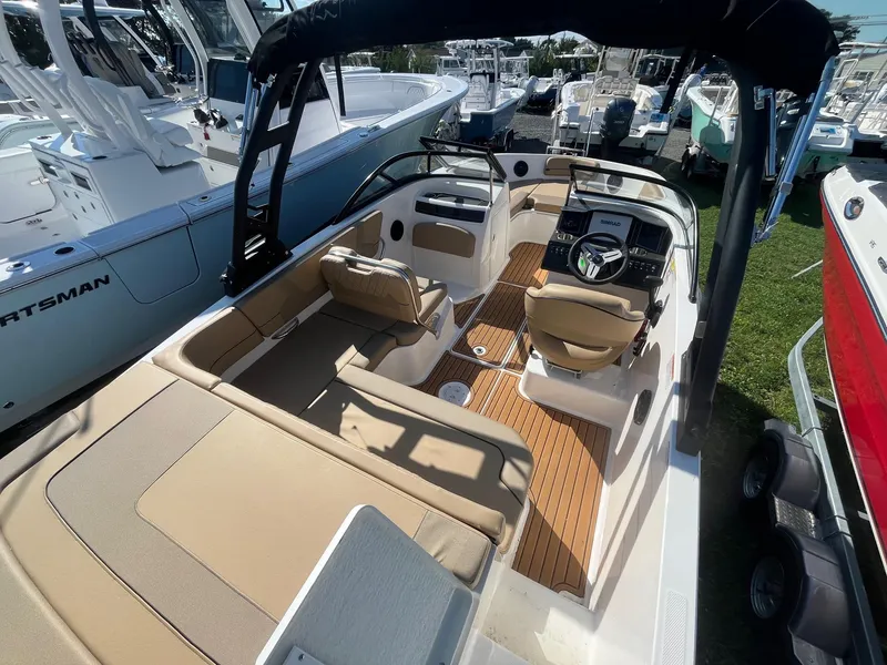 Slide: The Image of 2025 Bayliner VR5 Bowrider OB interior with seating and steering wheel, displayed outdoors. - 14