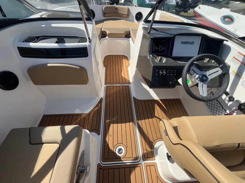 Slide: The Image of 2025 Bayliner VR5 Bowrider OB interior with tan seating and wood-style flooring. - 18