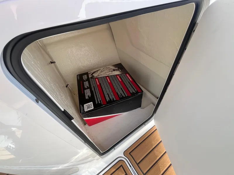Slide: The Image of Storage compartment on 2025 Bayliner VR5 Bowrider OB with a box inside. - 22