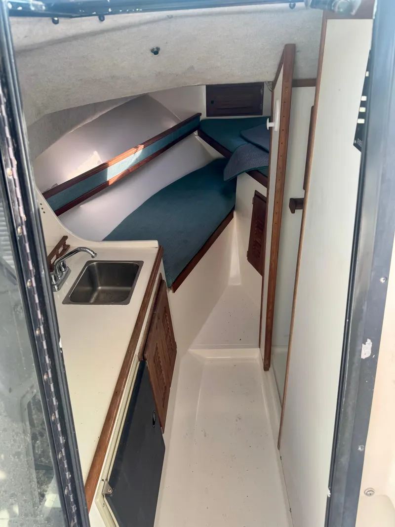 Slide: The Image of 1998 Regulator 26 Express cabin interior with sink, bed, and storage. - 11