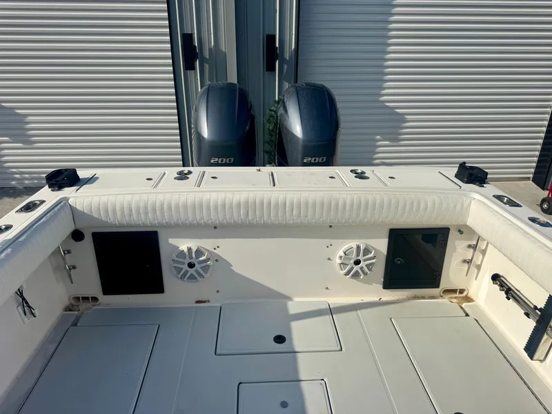 Slide: The Image of 1998 Regulator 26 Express boat deck with twin 200 engines and storage compartments. - 13