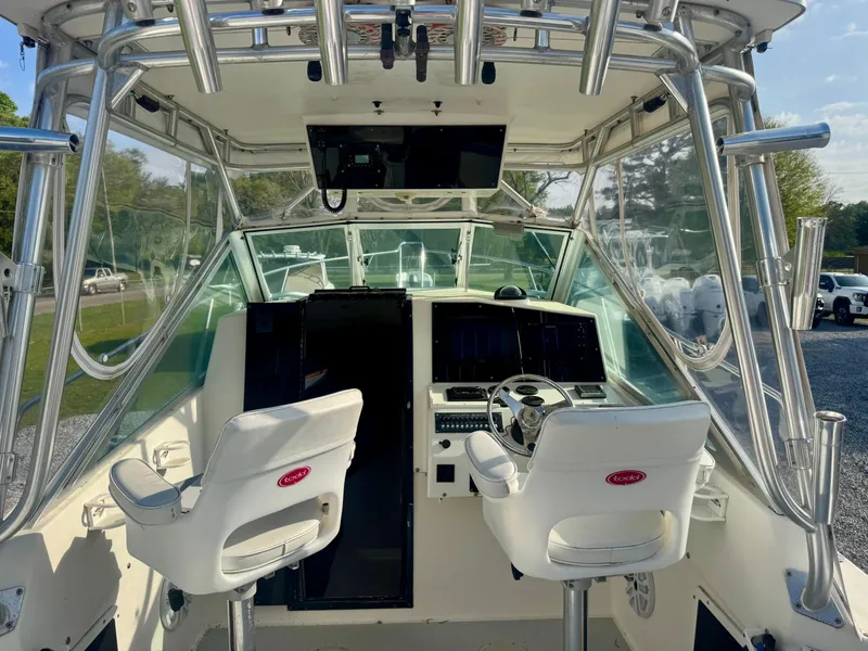 Slide: The Image of Interior view of a 1998 Regulator 26 Express boat cockpit with dual white seats. - 14